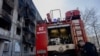 A firefighter leans on a fire truck near a damaged residential building following a strike in Dobropillia, Donetsk region, on March 8, 2025, amid the Russian invasion of Ukraine. 