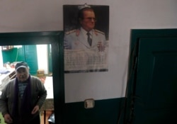 Uros Trainovic walks inside his house decorated with a picture of former Yugoslav communist leader Josip Broz Tito, in the village of Blagojev Kamen, Serbia, Jan. 23, 2020.