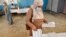 Une femme ramasse un bulletin de vote dans un bureau de vote à Bouchaoui, dans la banlieue ouest d'Alger, la capitale algérienne, le 12 juin 2021, lors des élections législatives de 2021.