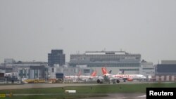 FILE - Aircraft taxi at Gatwick Airport in southern Britain, Dec. 17, 2015. British officials say three men and a woman were taken into custody in Birmingham Thursday, while another man was held at London's Gatwick Airport on Friday, April 15, 2015.