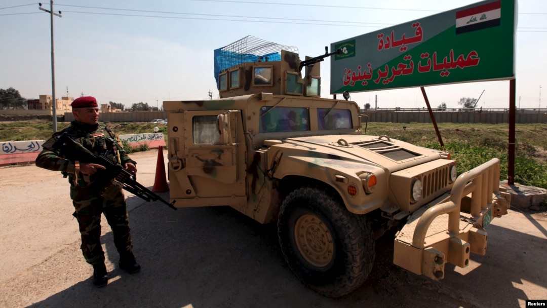 Iraqi army members stand guard at the entrance to the Nineveh Liberation Operations Command at Makhmour base, south of Mosul, Iraq, March 13, 2016.