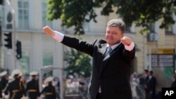 Presiden Ukraina Petro Poroshenko mengangkat tangannya menyambut hadirin seusai pelantikannya sebagai Presiden di Lapangan Sophia, Kyiv, Ukraina (7/6).