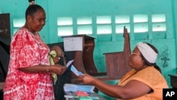 A woman votes in a referendum on whether to adopt a new constitution, in Libreville, Gabon, on Nov. 16, 2024.