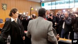 Onesphore Rwabukombe est photographié par les médias alors qu'il attend le début de son procès devant un tribunal de Francfort, centre de l'Allemagne, mardi 18 janvier 2011. 