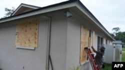 Un residente pone tablas en sus ventanas en Palm Harbor, Florida, antes de la prevista llegada del huracán Milton a mitad de semana, el domingo 6 de octubre de 2024.