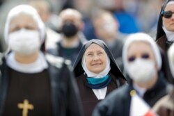 Religiosas miran al papa Francisco en el balcón de la Basílica al mediodía del domingo desde la plaza de San Pedro mientras pronuncia la oración a la Virgen usada en tiempo de Pascua. Abril 18 de 2021.