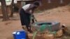 A woman draws water from an unprotected well in Chigwirizano, a peri-urban area hit by a Cholera outbreak in Malawi. (Photo: Lameck Masina for VOA)