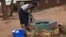A woman draws water from an unprotected well in Chigwirizano, a peri-urban area hit by a Cholera outbreak in Malawi. (Photo: Lameck Masina for VOA)