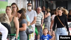 FILE - People line up to enter a grocery store in Brisbane, Australia, Jan. 8, 2021. 