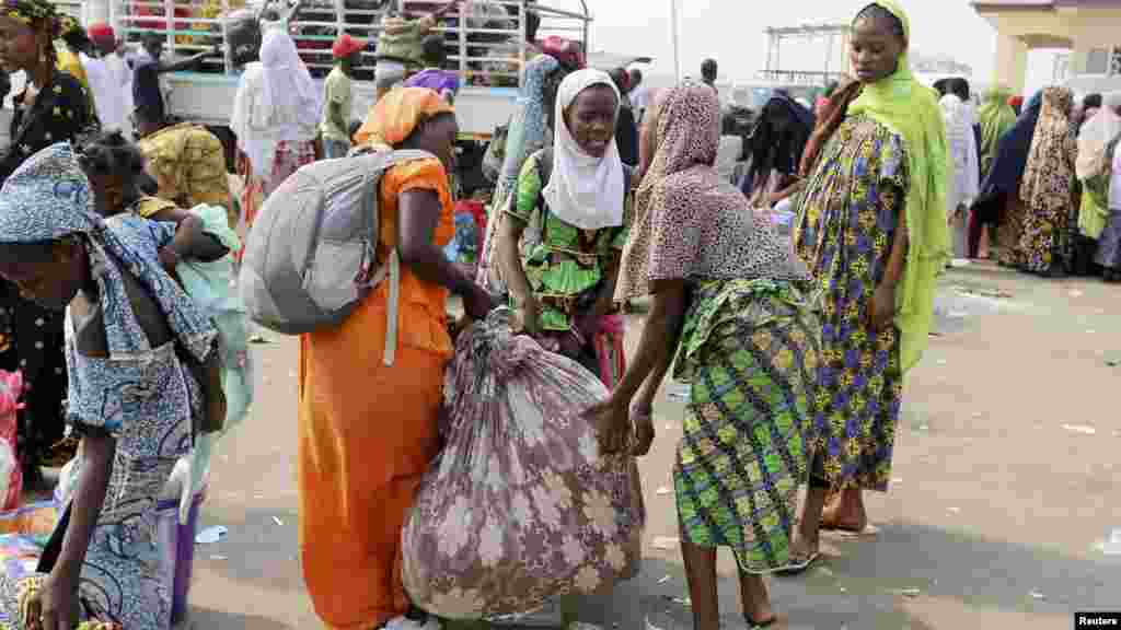 &#39;Yan Najeriya da aka kwaso daga Afirka Ta Tsakiya suna shirin su yi balaguro zuwa garuruwansu dake jihohi daban daban daka filin saukar jiragen sama na kasa da kasa na Nnamdi Azikiwe dake Abuja ranar 6 ga watan Janairu na shekarar 2014.