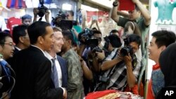 Pendiri Facebook Mark Zuckerberg (dua dari kiri) bersama Presiden Terpilih Joko Widodo (kiri) berbincang dengan salah seorang pedagang saat 'blusukan' di pasar Tanah Abang, Jakarta (13/10).