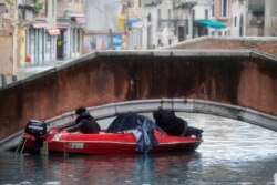A boat tries to pass under a bridge during a period of seasonal high water in Venice, Italy, Nov. 15, 2019.