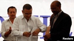 El Salvador's President Mauricio Funes and Daniel Yohannes (R), executive director of MCC, at a school MCC helped fund. 