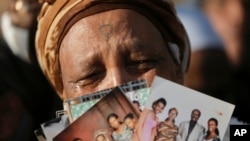 Mwanamke wa asili ya Ethiopian akionyesha picha za jamaa yake wakati wa maandamano nje ya bunge la Israeli mjini Jerusalem.