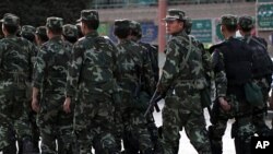 Armed police officers patrol an ethnically Uighur area in Kashgar, in Xinjiang province August 4, 2011