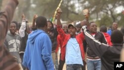 FILE: People thong on the streets as they protest and clash with Zimbabwean police in Harare, Monday, July, 4, 2016. Police in Zimbabwe's capital fired tear gas and water cannons in an attempt to quell rioting by taxi and mini bus drivers protesting what they describe as police harassment. The violence came amid a surge in protests in recent weeks because of economic hardships and alleged mismanagement by the government of President Robert Mugabe. (AP Photo/Tsvangirayi Mukwazhi)