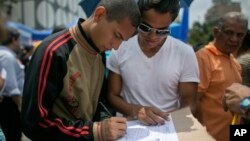 A man signs a petition to initiate a recall referendum against Venezuela's President Nicolas Maduro in Caracas, April 27, 2016. 