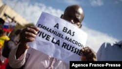 FILE - A man holds up a sign reading "Down with Emmanuel Macron, long live Russia," during a rally in Bamako, Mali, Jan. 14, 2022, against former colonial power France, which still maintains a military presence in Mali.