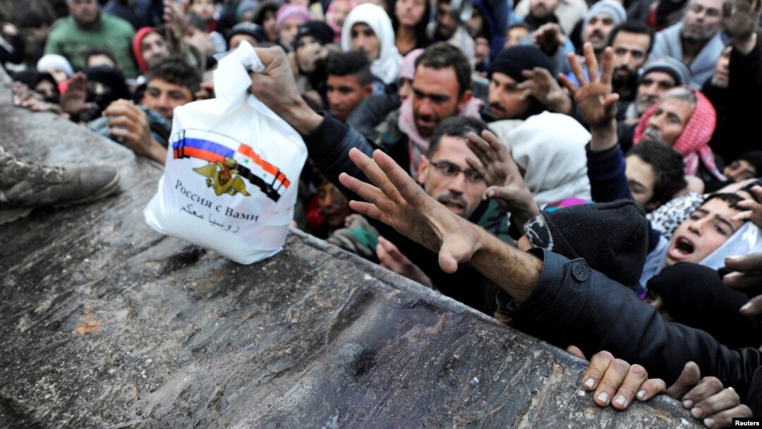 Para pengungsi Suriah yang meninggalkan Aleppo timur, menunggu pembagian makanan dari pasukan Rusia di distrik Jibreen, Aleppo hari Rabu (30/11).