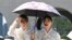 韩国首都首尔景福宫内，身穿传统韩服的游客撑起阳伞躲避烈日。(2026年8月3日)