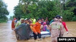 Tim SAR mengevakuasi penduduk desa dengan perahu karet di daerah banjir di kabupaten Tanah Laut, Kalimantan Selatan, 15 Januari 2021. (Foto: BNPB via AFP)