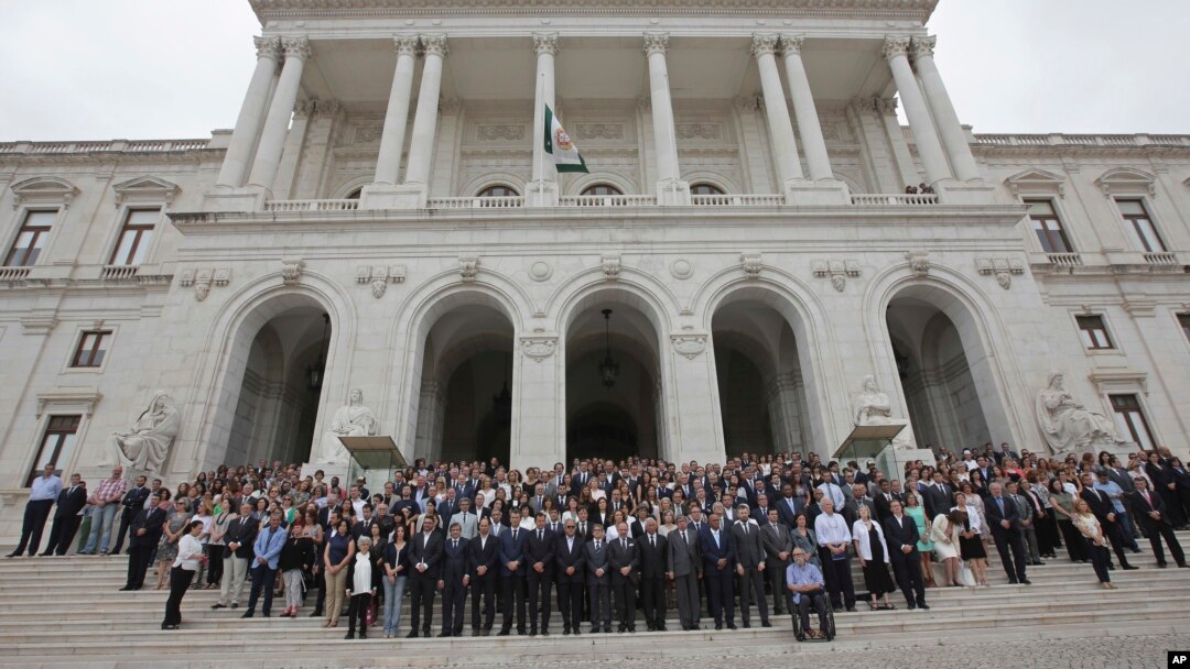 Portuguese Prime Minister Antonio Costa, center, joins members of the government and lawmakers on the steps of the parliament building in Lisbon, June 21, 2017, to observe a minute of silence in memory of the victims of a wildfire.