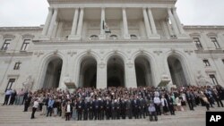 Portuguese Prime Minister Antonio Costa, center, joins members of the government and lawmakers on the steps of the parliament building in Lisbon, June 21, 2017, to observe a minute of silence in memory of the victims of a wildfire.