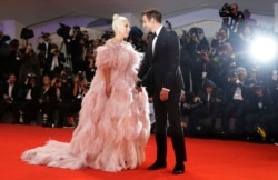 FILE - Actress and singer Lady Gaga, left, and actor Bradley Cooper pose for photographers upon arrival at the premiere of the film 'A Star Is Born' at the 75th edition of the Venice Film Festival in Venice, Italy.
