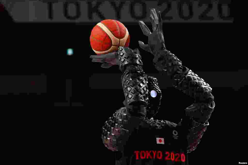 A Japanese basketball robot shoots the ball during half time of the women&#39;s game between Belgium and Puerto Rico during the Tokyo 2020 Olympics at Saitama Super Arena, in Saitama, Japan.