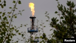 FILE - A flame burning natural gas is seen at an oil refinery located on a branch of the Druzhba oil pipeline, which moves crude through the pipeline westwards to Europe, near Mozyr, some 300 km (186 miles) southeast of Minsk, Belarus, Sept. 11, 2013. 