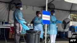 FILE - Medical personnel wait to conduct Covid-19 testing in Miami, on Sept. 1, 2021. 