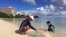 Kenji Kikuchi plays with his son Hideki in Ypao Beach, Tumon, Guam, Aug. 14 2017. 