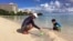 Kenji Kikuchi plays with his son Hideki in Ypao Beach, Tumon, Guam, Aug. 14 2017. Kikuchi was aware of the threat from reading the local newspaper and was a little worried. 