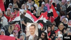 Partidarios del presidente sirio Bashar Al-Assad, esperan por el discurso del gobernante.