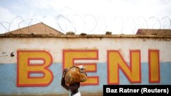 Un garçon passe devant le mur d'un centre de traitement du virus Ebola à Beni, en RDC, le 1er avril 2019. REUTERS/Baz Ratner