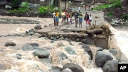 Afectados por el huracán Sandy en Jamaica, observan la fuerza de la corriente en el río Hope. Sandy dejó 21 muertos a su paso por el Caribe.