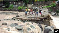 Warga mengamati jembatan yang sempat rusak dilanda topan Gustav tahun 2008 di desa Kintyre dekat Kingston, Jamaika, pasca Topan Sandy (25/10).