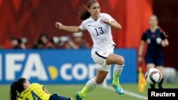 La estadounidense Alex Morgan (13) supera la marca de la colombiana Nataly Arias durante el juego del Mundial femenino en Edmonton, Alberta, en el que Estados Unidos pasó a cuartos de final.