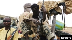 Militiaman from the Ansar Dine Islamic group sit on a vehicle in Gao in northeastern Mali.