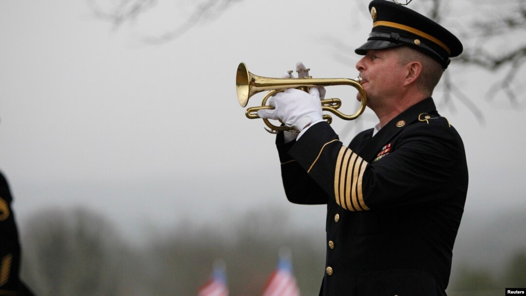 FILE - Taps is played by a lone bugler during the funeral for Korean War veteran Private First Class Glenn Schoenmann in Palmer, Tennessee, Jan. 12, 2013. 