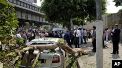 Petugas keamanan Mesir memeriksa lokasi ledakan bom di jalan ramai di tengah kota Kairo, Mesir, Minggu, 21 September 2014. (AP Photo/Aly Hazzaa, El Shorouk)