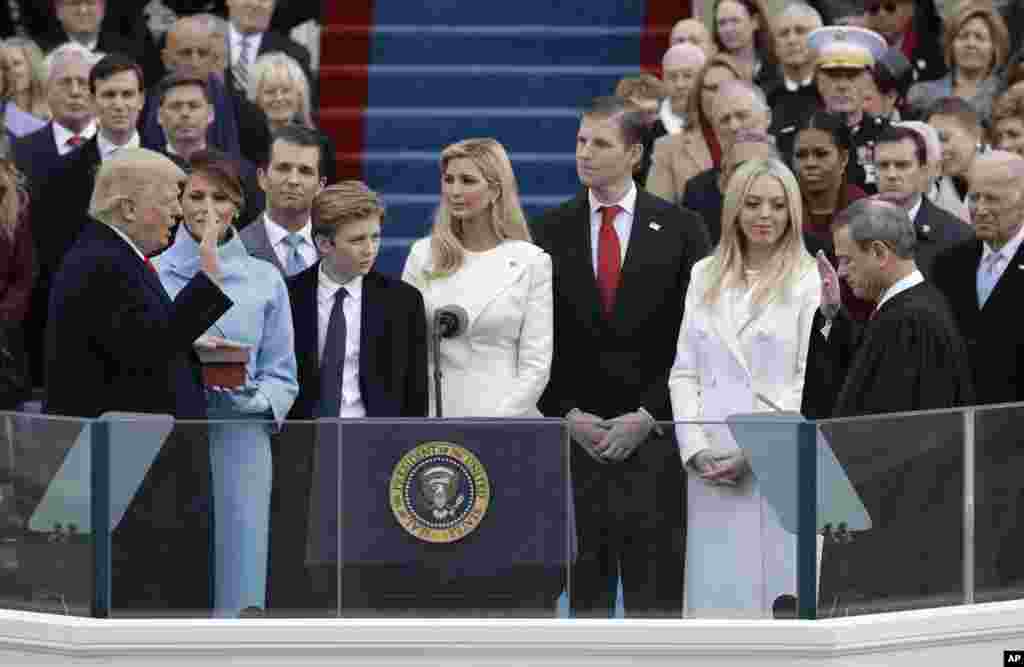 Donald Trump is sworn in as the 45th president of the United States by Chief Justice John Roberts as Melania Trump and his family looks on during the 58th Presidential Inauguration at the U.S. Capitol in Washington, Jan. 20, 2017. 