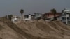 ARCHIVO - Casas frente al mar tapadas detrás de una montañas de arena reforzada como preparativos para enfrentar una tormenta en la playa de Long Beach, California, el 9 de septiembre de 2022.