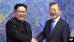 Pemimpin Korea Utara Kim Jong Un (kiri) dan Presiden Korea Selatan Moon Jae-in di Panmunjom, 27 April 2018.