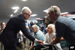 El fiscal de distrito del condado de Los Ángeles, George Gascón, estrecha la mano de la hermana de Kitty Menéndez, Joan Andersen VanderMolen, en una conferencia de prensa en el Salón de la Justicia el jueves 24 de octubre de 2024, en Los Ángeles. (Foto AP/Eric Thayer)