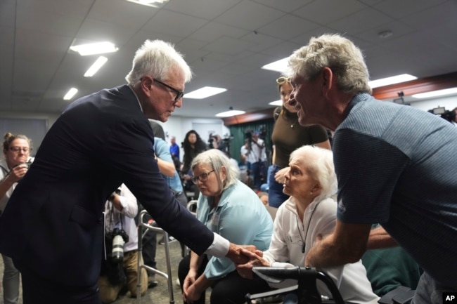 El fiscal de distrito del condado de Los Ángeles, George Gascón, estrecha la mano de la hermana de Kitty Menéndez, Joan Andersen VanderMolen, en una conferencia de prensa en el Salón de la Justicia el jueves 24 de octubre de 2024, en Los Ángeles. (Foto AP/Eric Thayer)