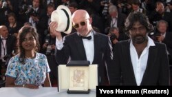 Sutradara film "Dheepan", Jacques Audiard (tengah), bersama aktris Kalieaswari Srinivasan (kiri) dan aktor Jesuthasan Antonythasan berpose setelah "Dheepan" memenangkan film terbaik di festival film Cannes, Perancis hari Minggu (24/5).