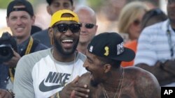 LeBron James de l'equipe de basket ball americaine de Clevenland, les Cavaliers, riant avec J.R. Smith