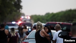 Sejumlah warga memadati lokasi ditemukannya puluhan orang dalam kondisi meninggal di dalam sebuah trailer di San Antonio, Texas, pada 27 Juni 2022. (Foto: Reuters/Kaylee Greenlee Beal)