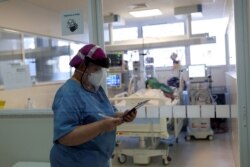 FILE - Nurse Eva Fiori updates a medical record of a patient suffering from the coronavirus disease (COVID-19) at the Intensive Care Unit (ICU) of Emilio Ribas Institute in Sao Paulo, Brazil, June 17, 2020.